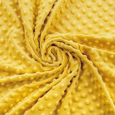 a close up shot of yellow fabric with small polka dots on the top and bottom