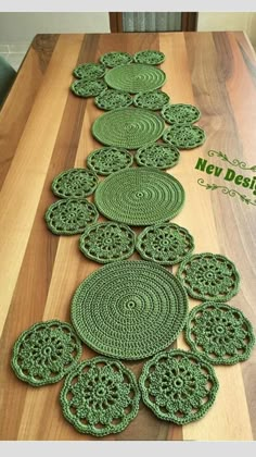 green crocheted placemats sitting on top of a wooden table