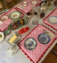 a table topped with plates and bowls filled with food on top of a white table cloth