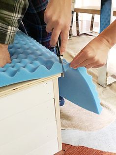 two people are working on some kind of roofing material that is being used to build a house