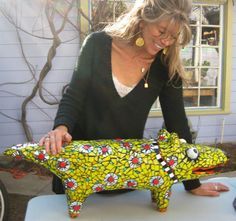 a woman is working on an animal made out of paper mache and cloths