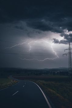 a road that has some lightning in the sky