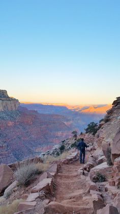 a man hiking up the side of a mountain at sunset