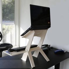 a laptop computer sitting on top of a wooden stand