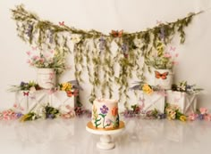 a cake sitting on top of a white plate next to a wall with flowers and butterflies