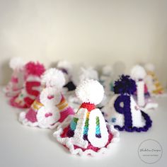 small crocheted hats with numbers and pom poms