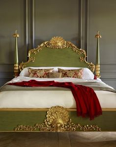 a green bed with gold headboard and foot board, red blanket on the bottom