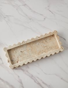 a white marble tray with scalloped edges