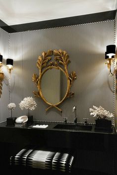 a black and white bathroom with a mirror on the wall next to a vanity table