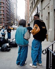 two men standing on the sidewalk talking to each other