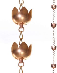 two pieces of metal hanging from chains with bells attached to each other, one has a chain and the other has a flower on it