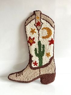 a crocheted cowboy boot sitting on top of a white table