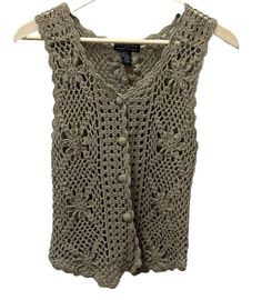 Vintage Womens One Step Sweater Vest  OS Tan Ramie Crochet Fairycore Grannycore This vintage sweater vest from One Step Up is a must-have for any fashion-forward woman. The floral crochet pattern and button accents give it a bohemian and grannycore vibe, making it perfect for a festival or casual outing. The open-knit design and lightweight ramie material make it breathable and comfortable to wear in any season. With a classic fit and sleeveless design, this sweater vest is versatile enough to wear as a vest or layer over a shirt. The V-neckline adds a touch of elegance, while the tan color and intricate crochet fabric type make it a unique addition to any wardrobe. Made in the China this sweater vest is a rare find for vintage clothing enthusiasts. 90s, Bohemian, Hippie, Fairycore, Granny Crochet Fairycore, Floral Crochet Pattern, Os Tan, 90s Bohemian, Vintage Sweater Vest, Vintage Pullover, Crochet Fabric, Floral Crochet, Vest Outfits