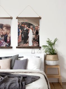 two pictures hanging on the wall above a bed with pillows, blankets and throw pillows