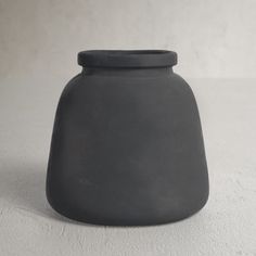 a black vase sitting on top of a white table