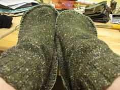 someone's feet in slippers on top of a desk