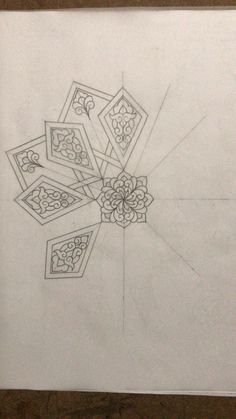 a pencil drawing of an intricate design in the middle of a piece of white paper