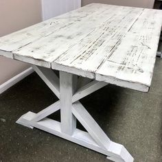 an old white table is sitting on the floor