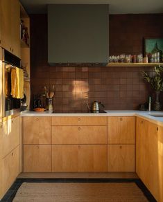 a kitchen with wooden cabinets and white counter tops is seen in this image from the side