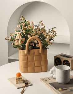 a table topped with a brown basket filled with flowers