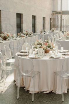 the tables are set with clear chairs and white linens for an elegant wedding reception