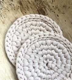 two crocheted round rugs sitting on top of a wooden floor