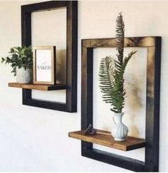 there are two wooden shelves with plants on them and one is holding a framed photo