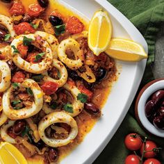 a white plate topped with shrimp and olives