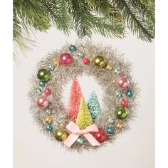 an ornament hanging from a christmas tree decorated with ornaments and bows on it