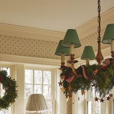 a chandelier hanging from the ceiling in a room with christmas wreaths on it