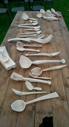 wooden spoons are lined up on a picnic table