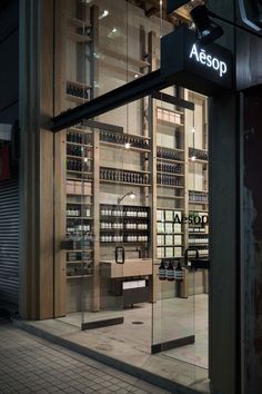 an aessop store front at night with its glass doors open and the lights on