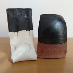 two ceramic objects sitting on top of a wooden table