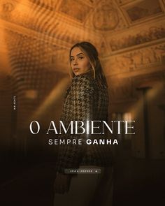 a woman standing in front of a wall with the words o ambiente sempre ganha on it