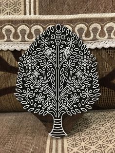 an intricately designed tree is on the back of a couch with white and black trim