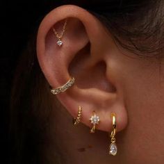 a woman wearing three different ear piercings