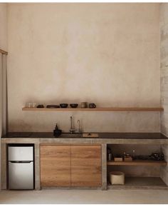 a kitchen with an oven, sink and shelves on the wall next to each other