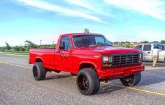 a red pick up truck parked on the side of the road