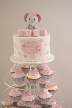 a baby shower cake with cupcakes and an elephant on top