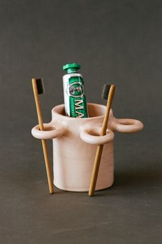 a toothbrush holder with two toothbrushes in it