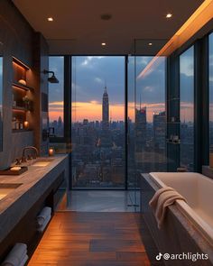 a bathroom with large windows and a view of the city at sunset or dawn,