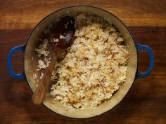 a blue pot filled with rice on top of a wooden table