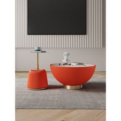 an orange and white table sitting on top of a wooden floor next to a painting