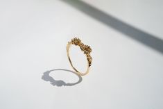 a gold ring sitting on top of a white table next to a shadow from the floor