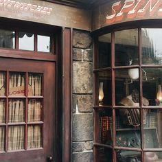 an old fashioned store front with many books in the window