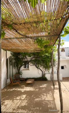 an outdoor covered patio with chairs and trees