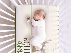 a baby laying on top of a white sheet