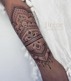 a woman's arm with a tattoo design on the left side of her arm