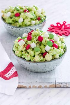 two bowls filled with green, red and white candies on top of a table