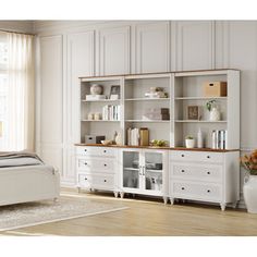 a white bed sitting in a bedroom next to a book shelf